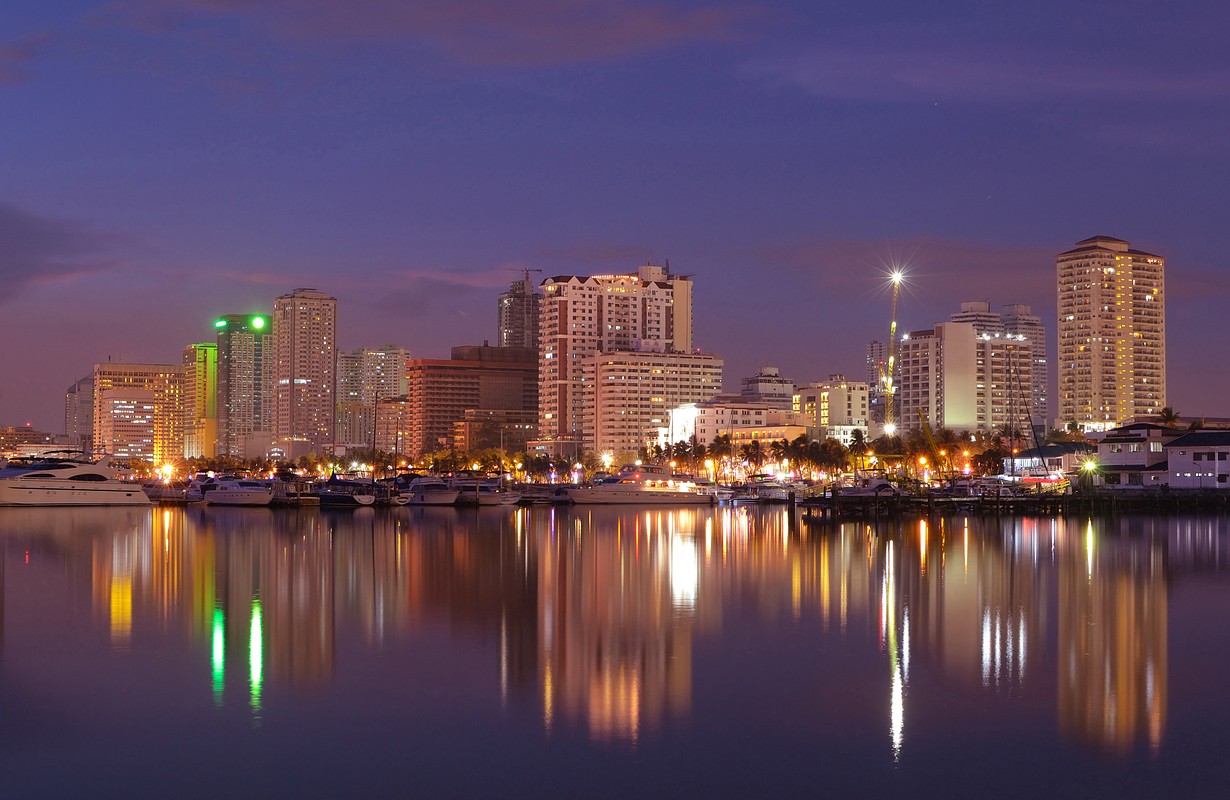 Vibrant Manila bay Philippines city night-scape and buildings reflection. 