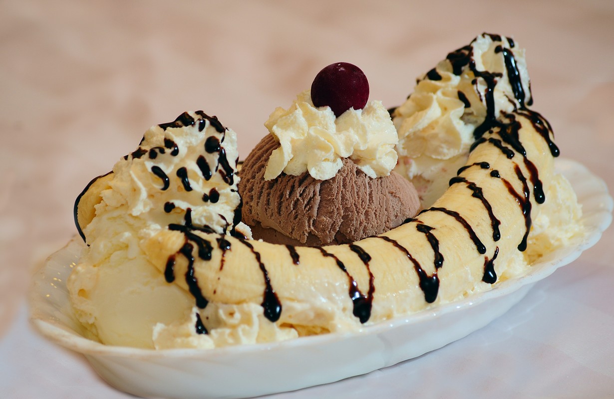 Delicious banana split on white plate - Picture.