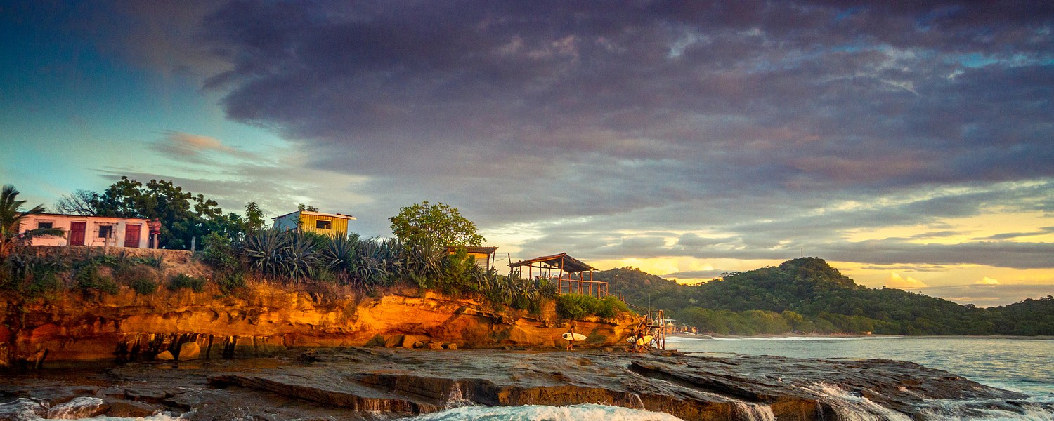 rocky beach with houses in sunset in Nicaragua