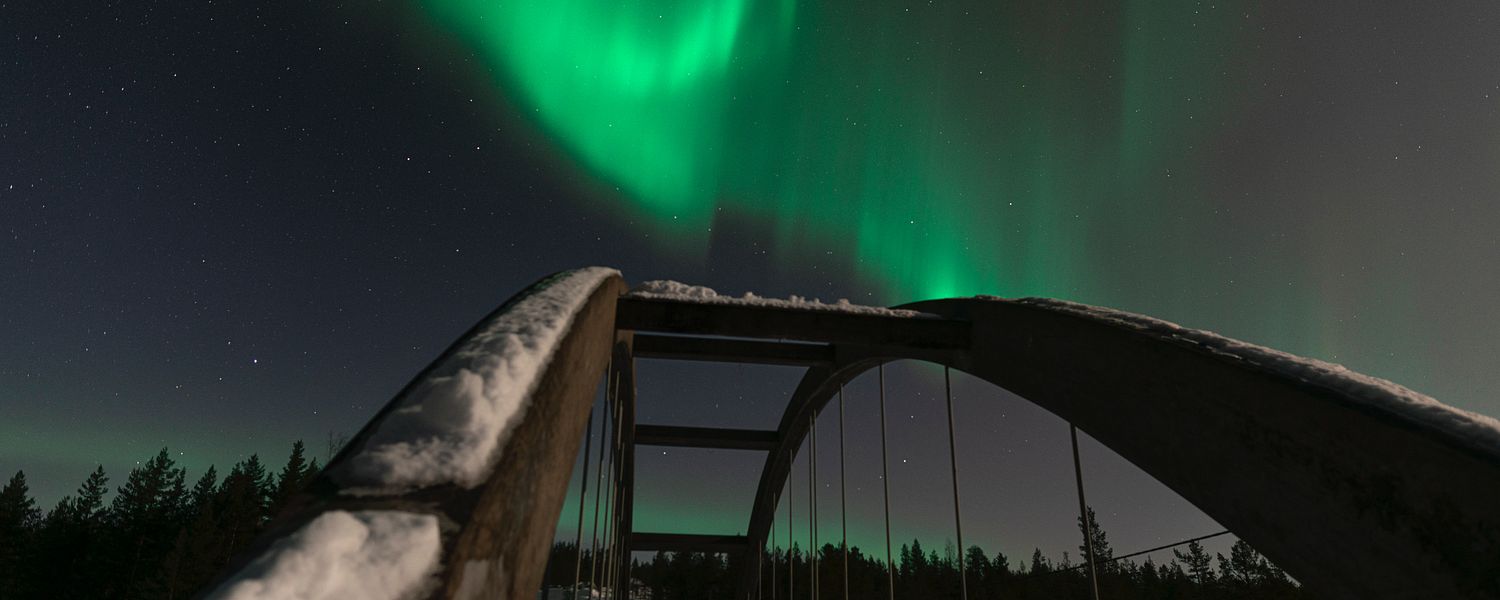 Northern Lights dancing across a bridge in Swedish Lapland