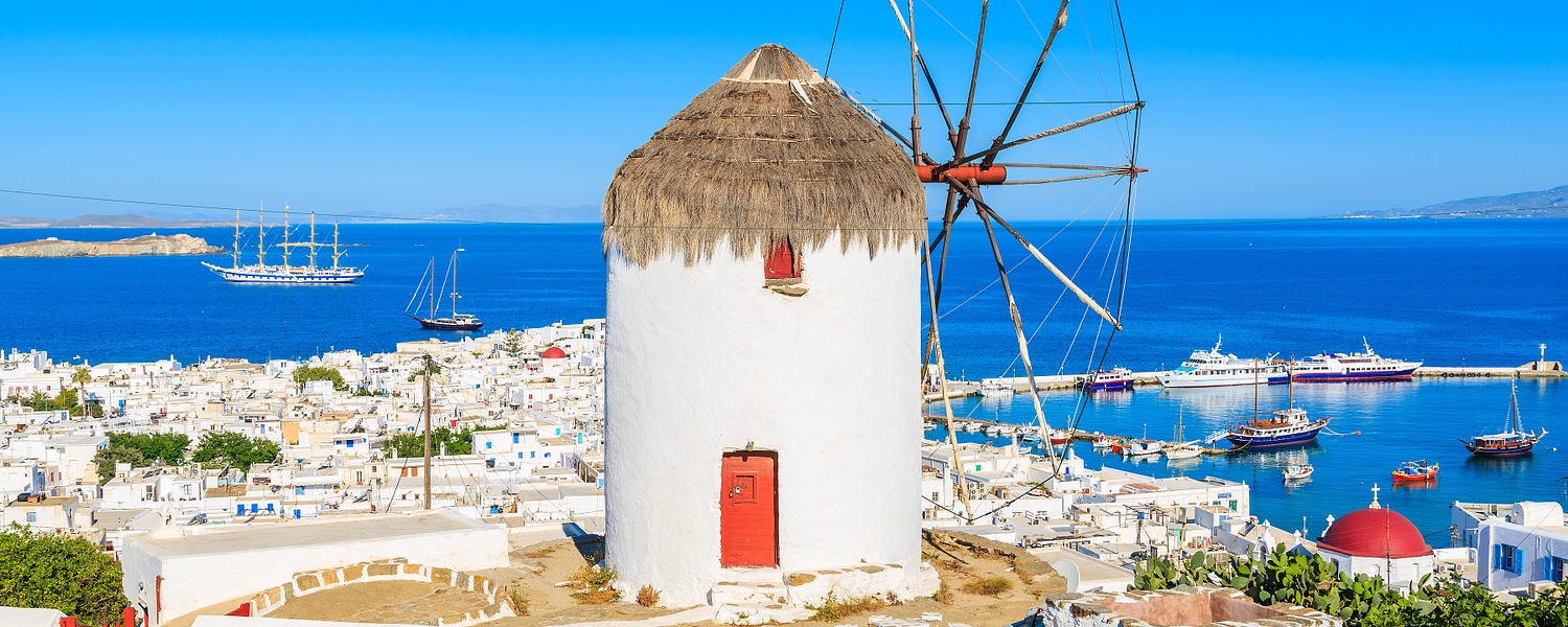 A view of famous traditional windmill overlooking Mykonos port, island of Mykonos, Cyclades, Greece