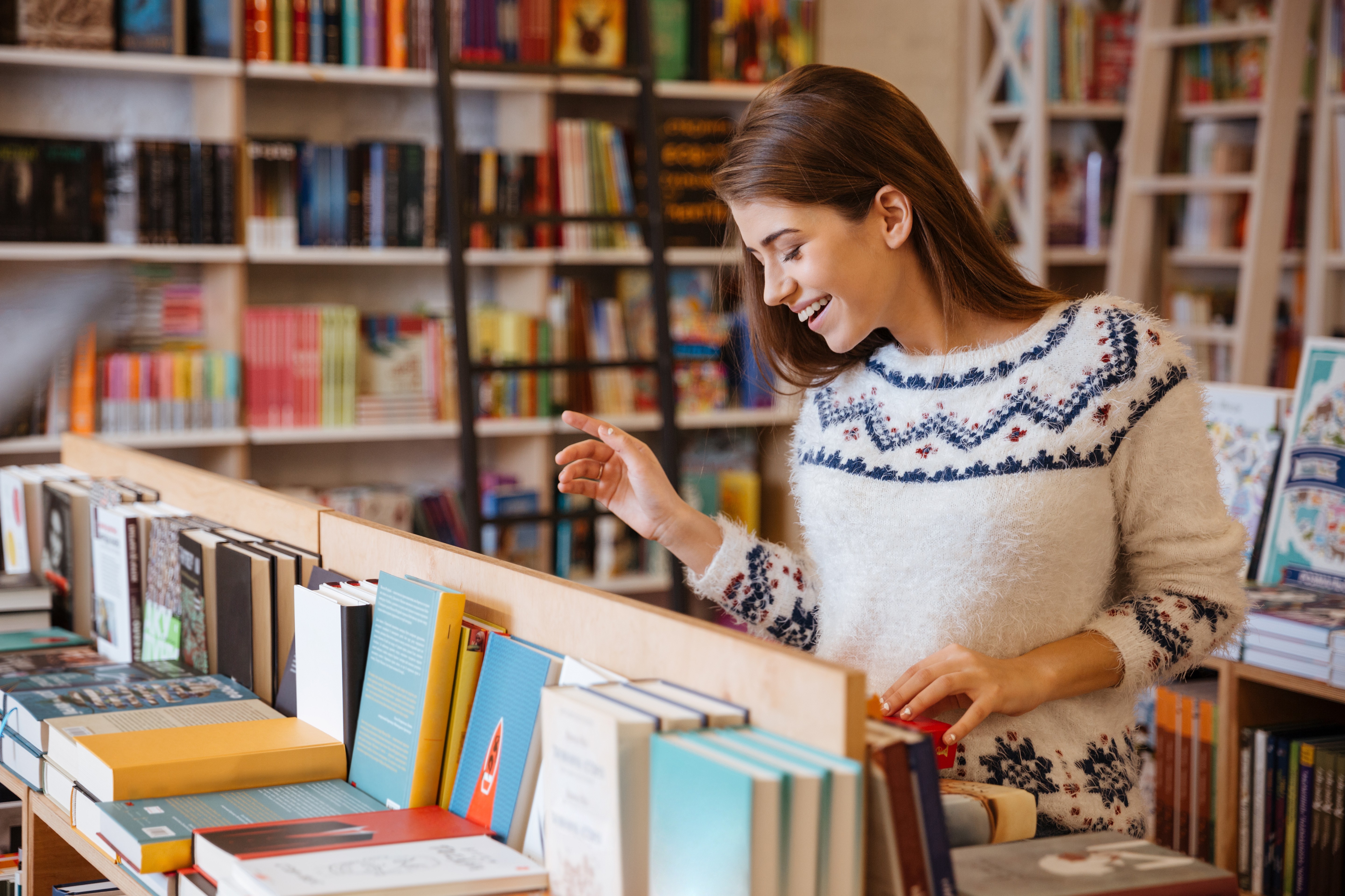 Заказать справочники. Человек выбирает книги в магазине. Девочка в книжном магазине. Книжный магазин картинки. Покупатели в книжном магазине.